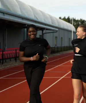 two girls running on track 